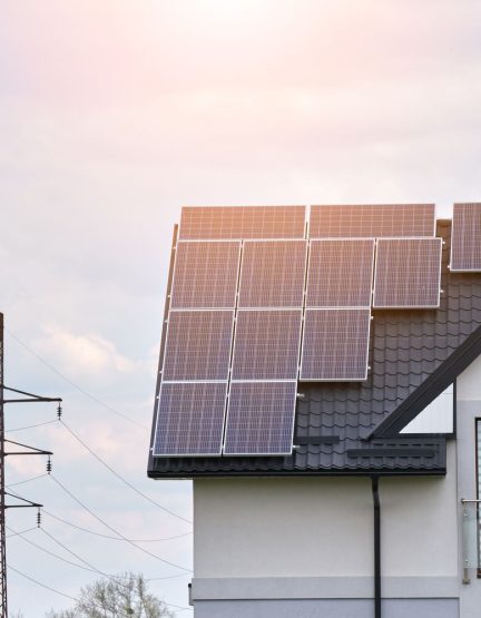 Residential house with rooftop covered with solar photovoltaic panels for producing of clean ecological electrical energy in suburban rural area. Concept of autonomous home.