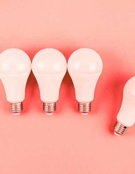 Energy-saving and eco-friendly life in conceptual frame pattern. Creative top view flat lay of LED light bulbs composition with copy space on coral toned background in minimal style.